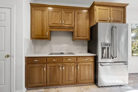 a kitchen with stainless steel appliances granite countertop a refrigerator a stove and a sink