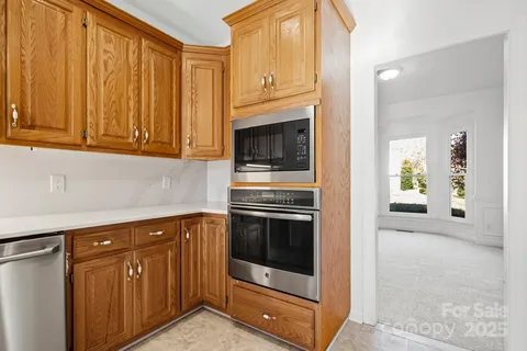 a kitchen with granite countertop cabinets stainless steel appliances and wooden cabinets