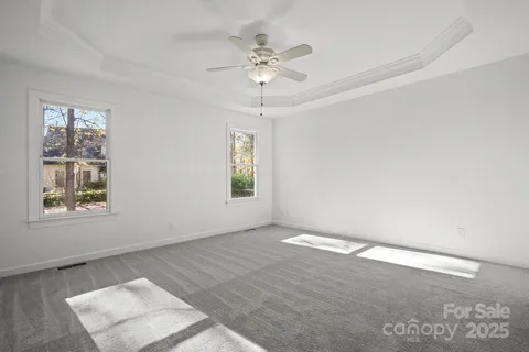 an empty room with a window and a ceiling fan