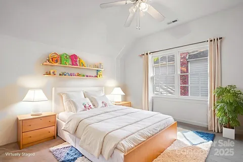 an empty room with a chandelier fan and windows