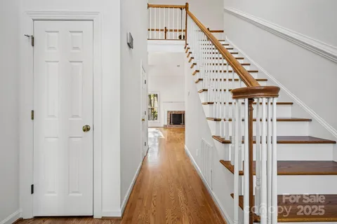 a view of a hallway with wooden floor and staircase