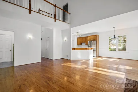 a view of a big room with wooden floor and a kitchen