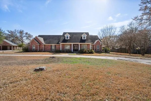 a front view of a house with a yard and trees