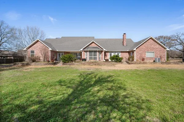a front view of a house with a yard and trees