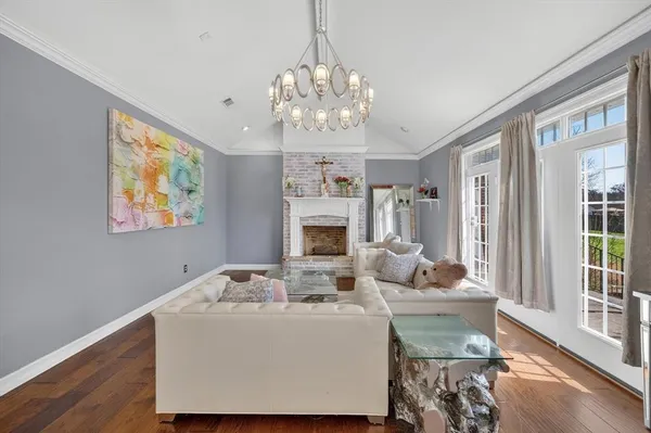 a living room with fireplace furniture and a chandelier