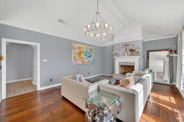 a living room with furniture a fireplace and a chandelier