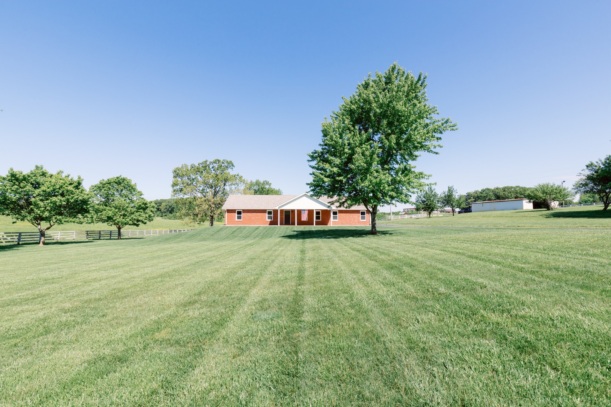 a front view of a house with a yard and trees