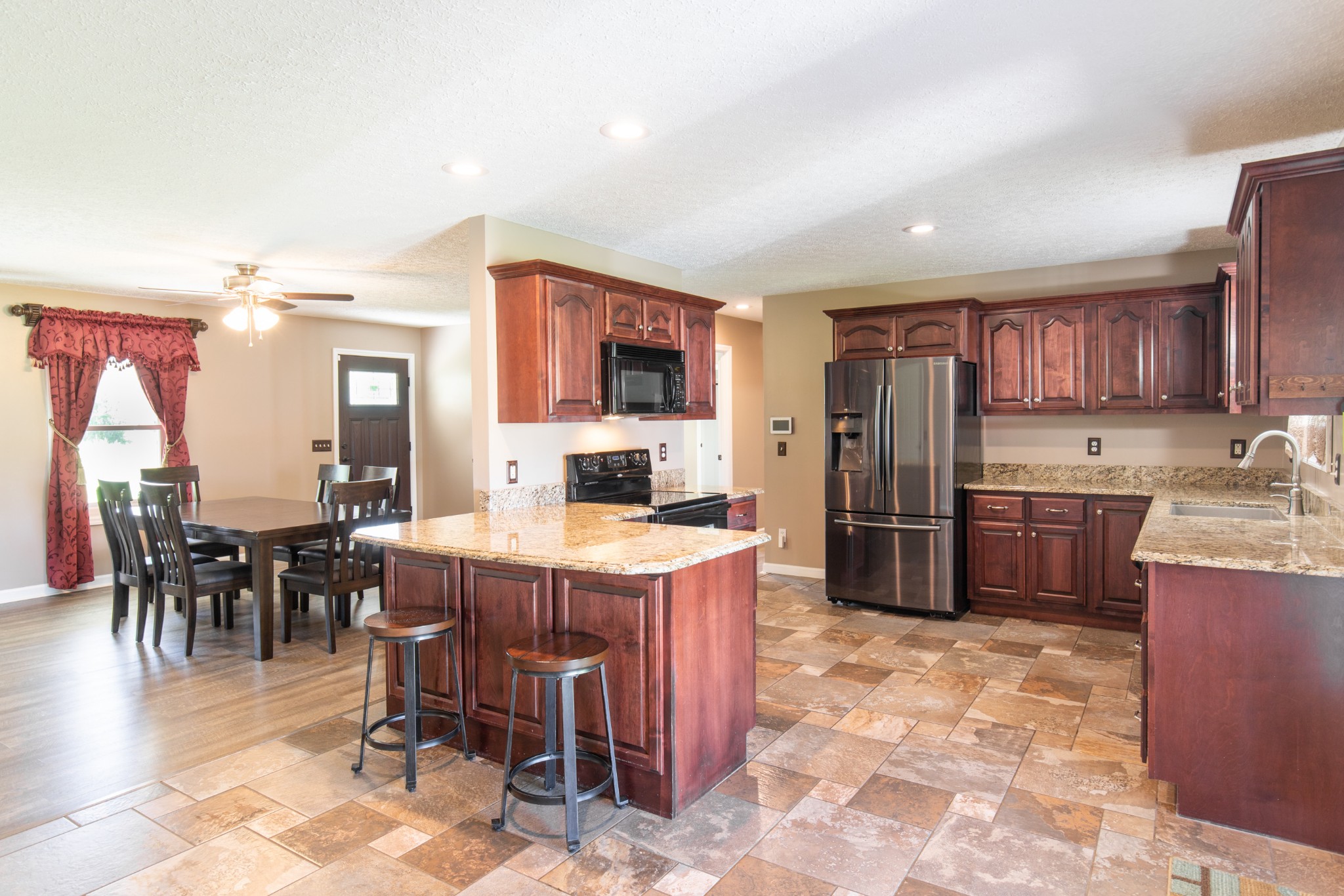 6022 Wayman Dunn Road Springfield, TN 37172 - Photo 11 of 35 a kitchen with refrigerator a stove a sink a dining table and chairs
