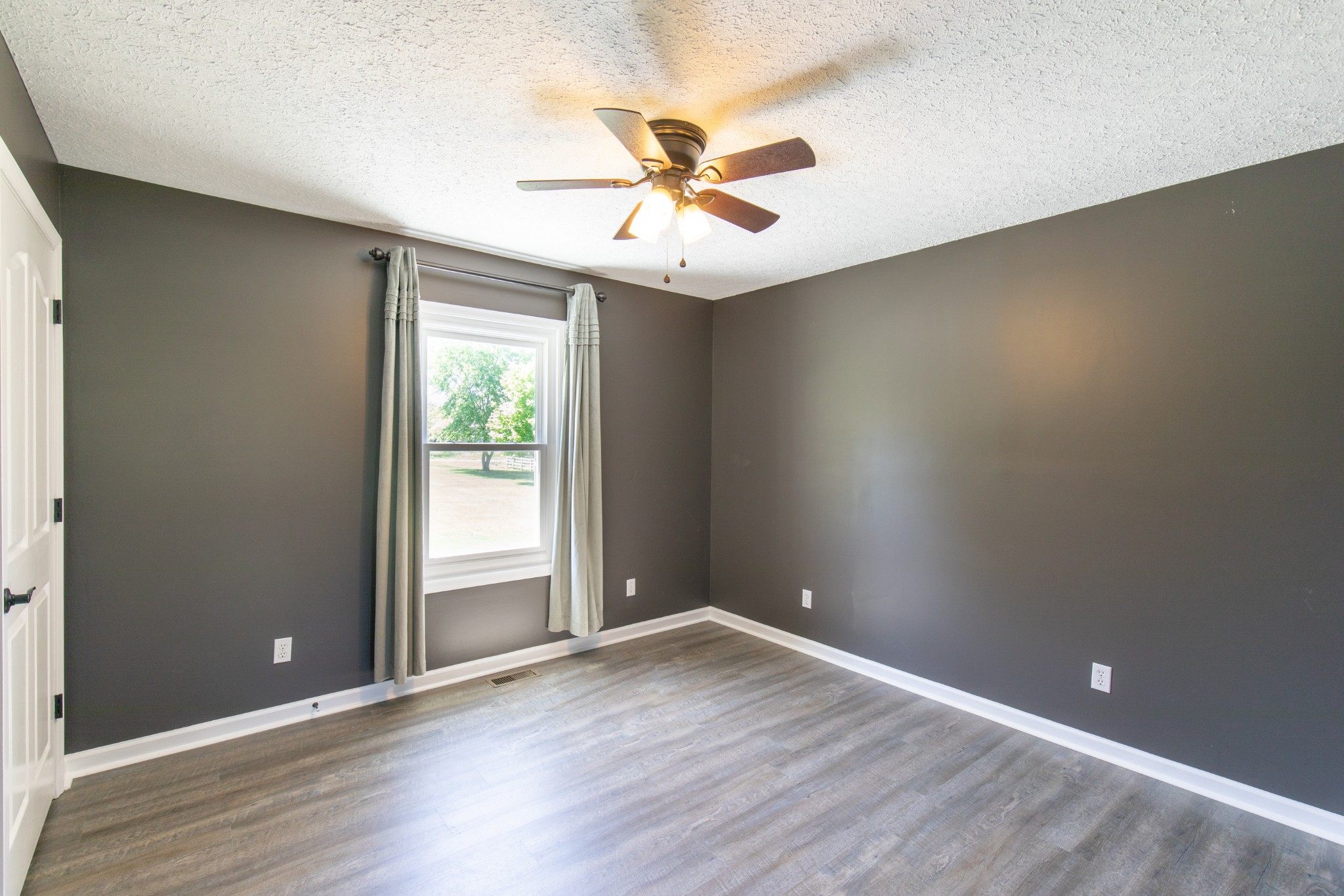 6022 Wayman Dunn Road Springfield, TN 37172 - Photo 32 of 35 an empty room with wooden floor fan and windows