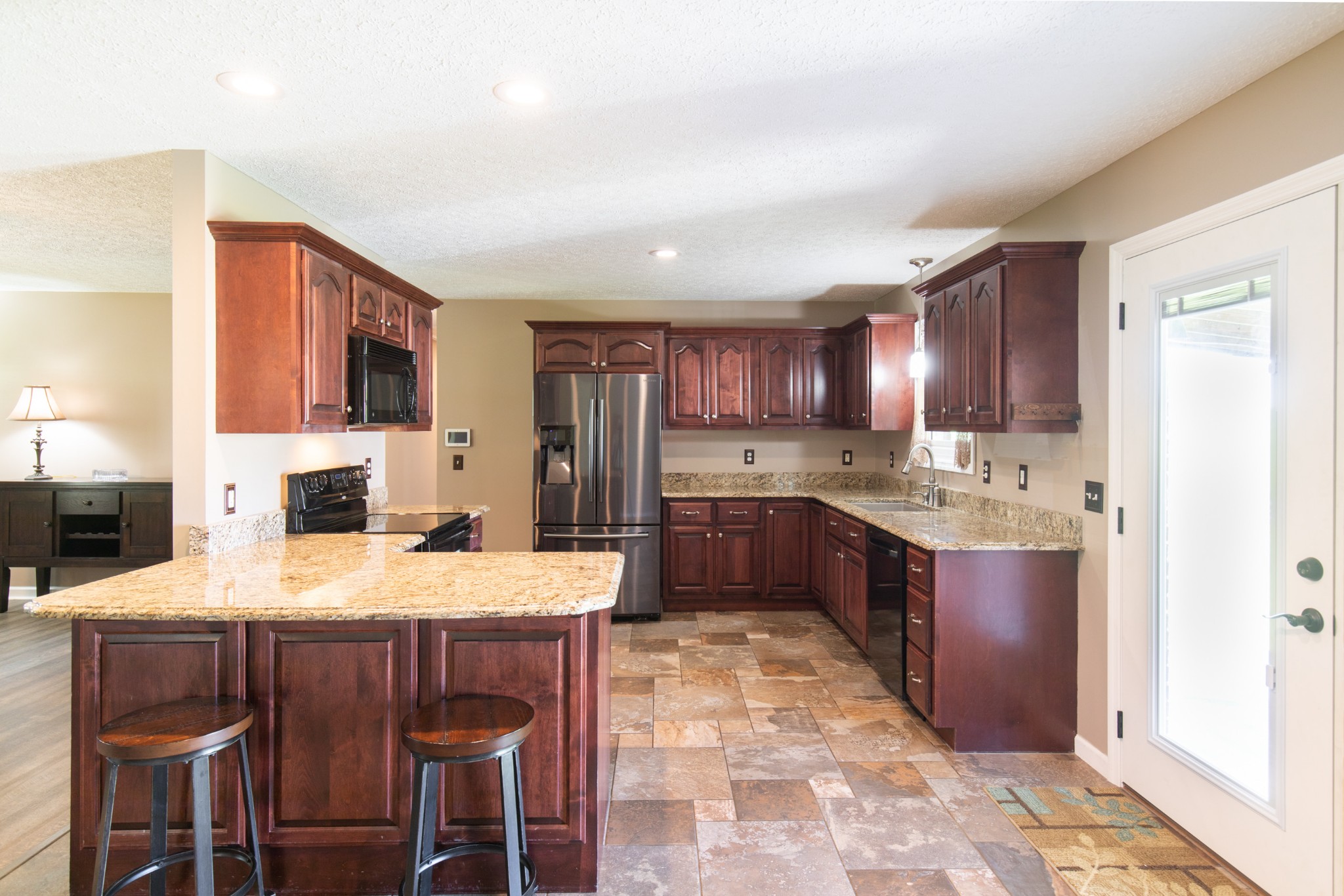 6022 Wayman Dunn Road Springfield, TN 37172 - Photo 9 of 35 a kitchen with stainless steel appliances granite countertop a table chairs sink refrigerator and cabinets