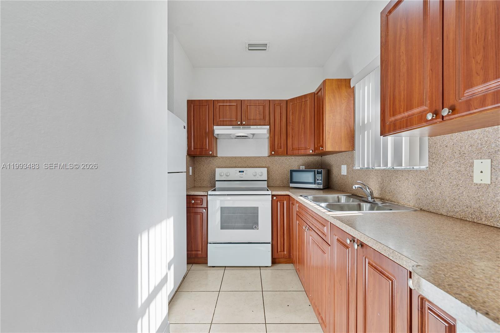 10357 Southwest 178th Street, Unit 10357 Miami, FL 33157 - Photo 14 of 25 a kitchen with a sink stove and cabinets
