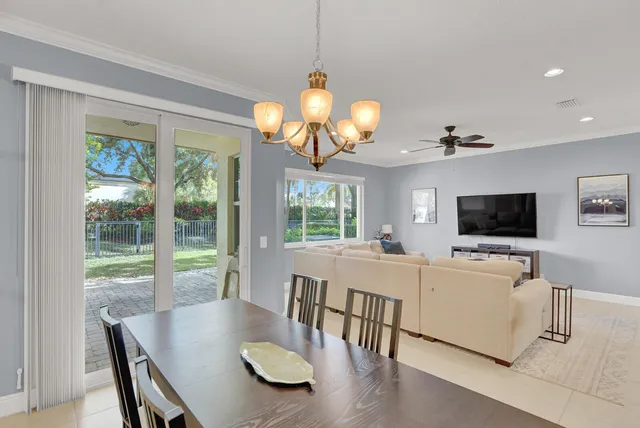 a view of a dining room with furniture a flat screen tv and a large window