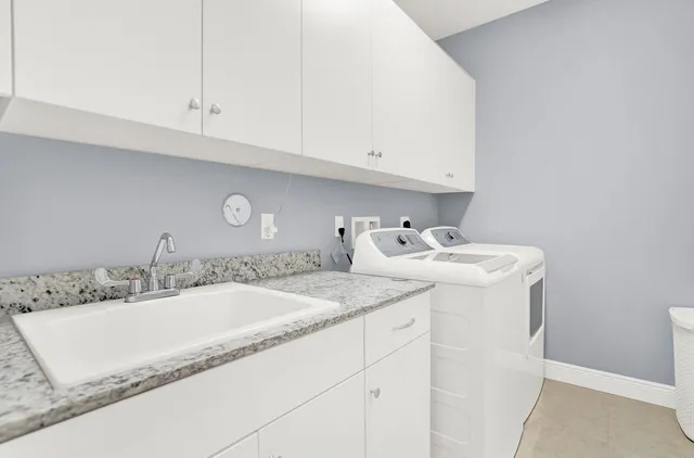 a bathroom with a granite countertop sink and white cabinets