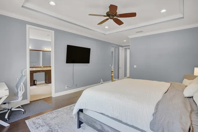 a bedroom with a bed a flat screen tv and couches