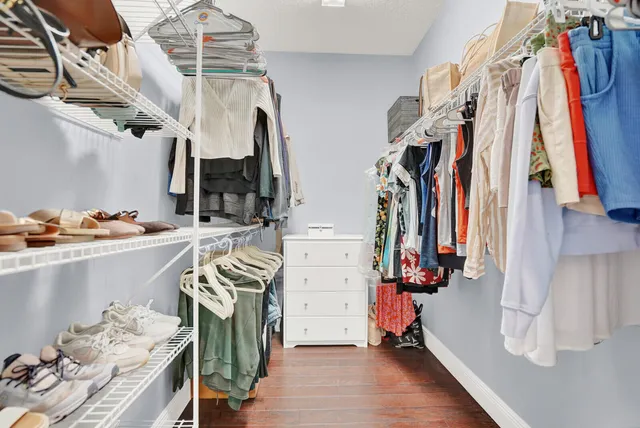 a view of walk in closet with clothes and shoes