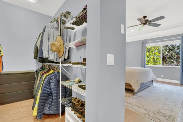 a view of walk in closet with clothes and shoes