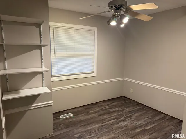 a view of a room with wooden floor and white walls
