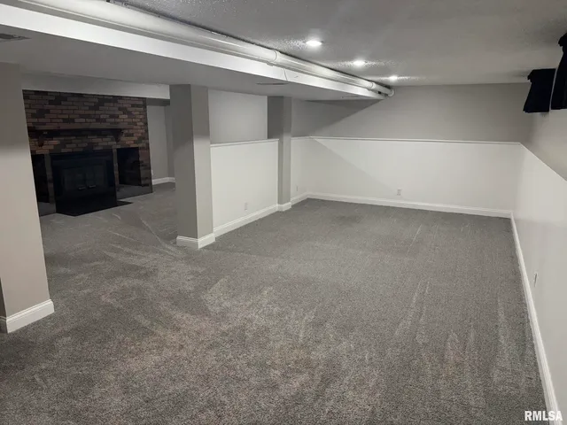 a view of a livingroom with an empty space and a fireplace