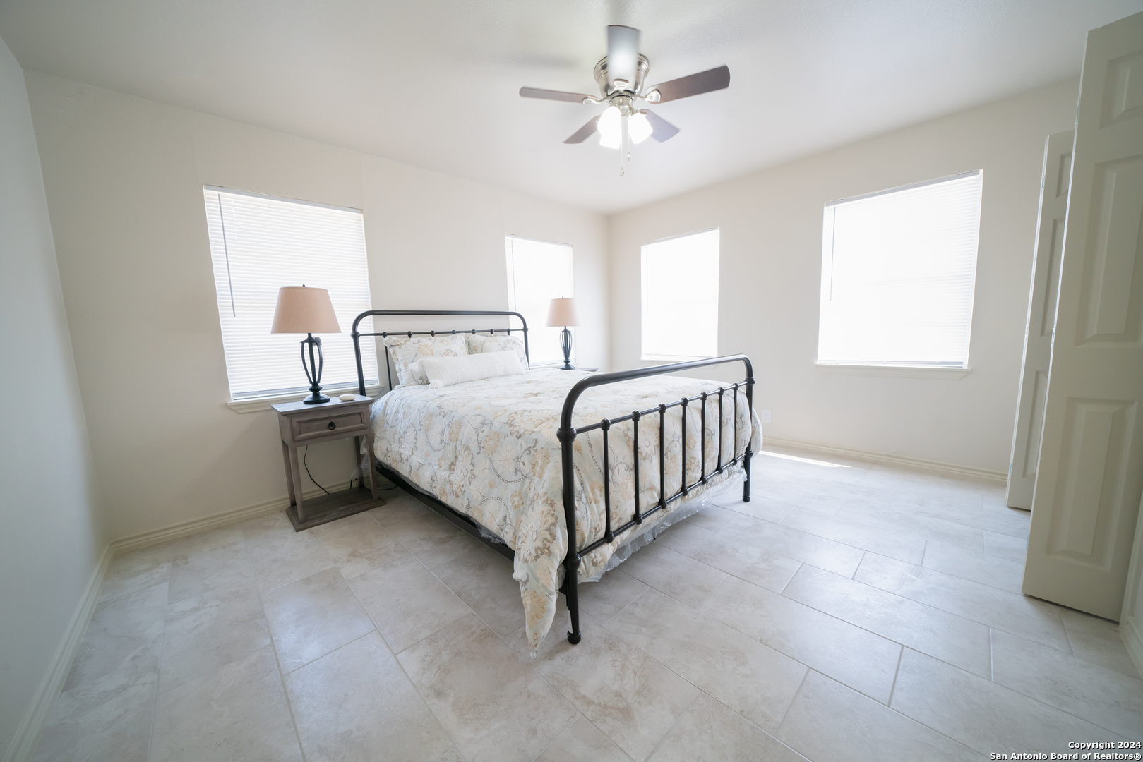 609 Hickory Highway Devine, TX 78016 - Photo 12 of 17 a bedroom with a bed chandelier and a window