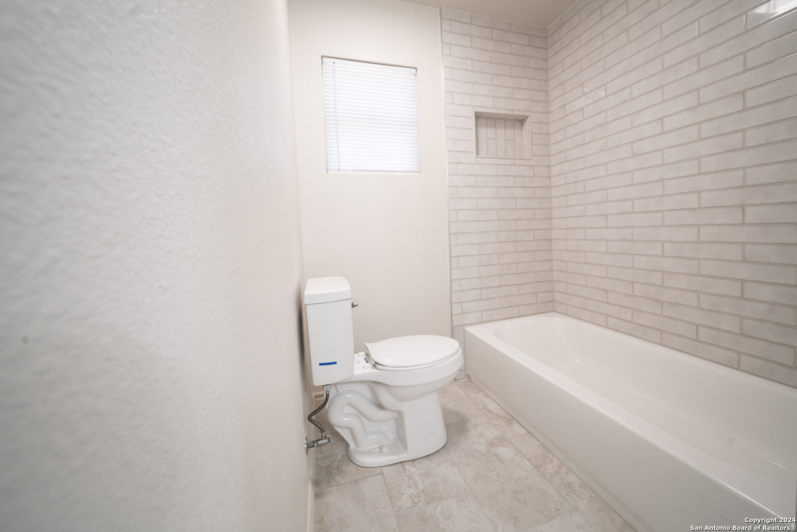 609 Hickory Highway Devine, TX 78016 - Photo 14 of 17 a white toilet sitting next to a bath tub