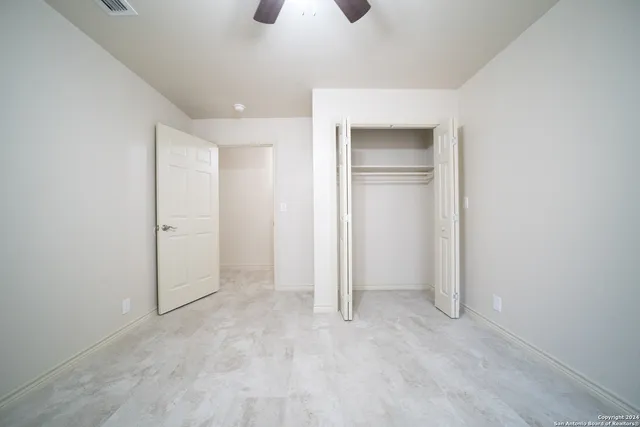 an empty room with closet and windows