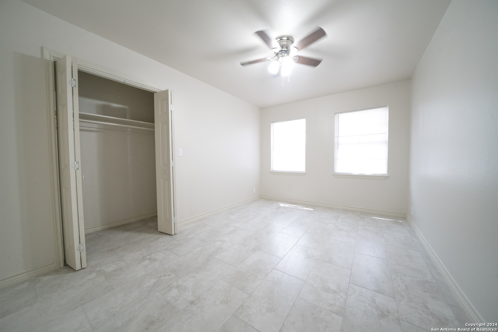609 Hickory Highway Devine, TX 78016 - Photo 8 of 17 an empty room with windows and chandelier fan