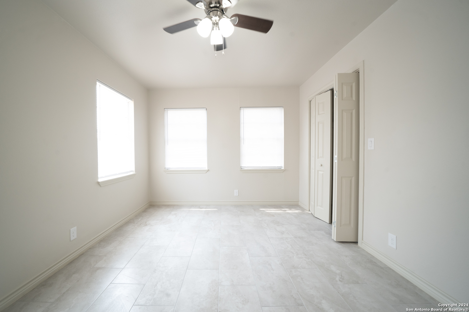 609 Hickory Highway Devine, TX 78016 - Photo 10 of 17 an empty room with windows and fan
