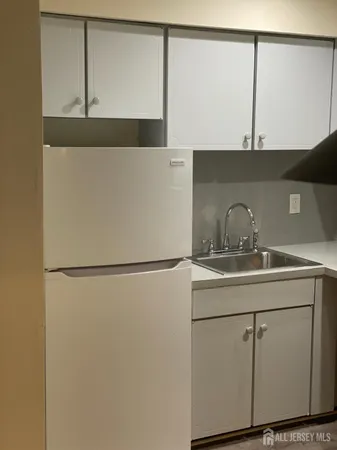 a close view of sink cabinets and refrigerator