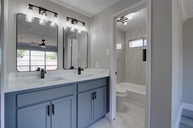 a bathroom with a double vanity sink mirror and bathtub