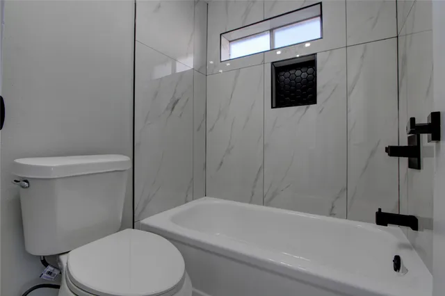 a bathroom with a toilet a sink and bathtub