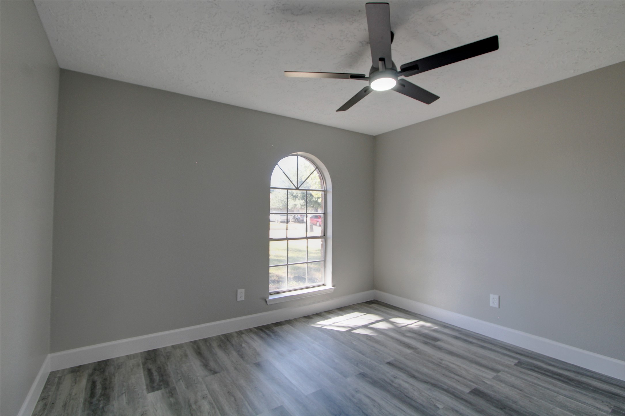 6830 Desert Rose Lane Houston, TX 77086 - Photo 19 of 20 an empty room with wooden floor chandelier fan and windows