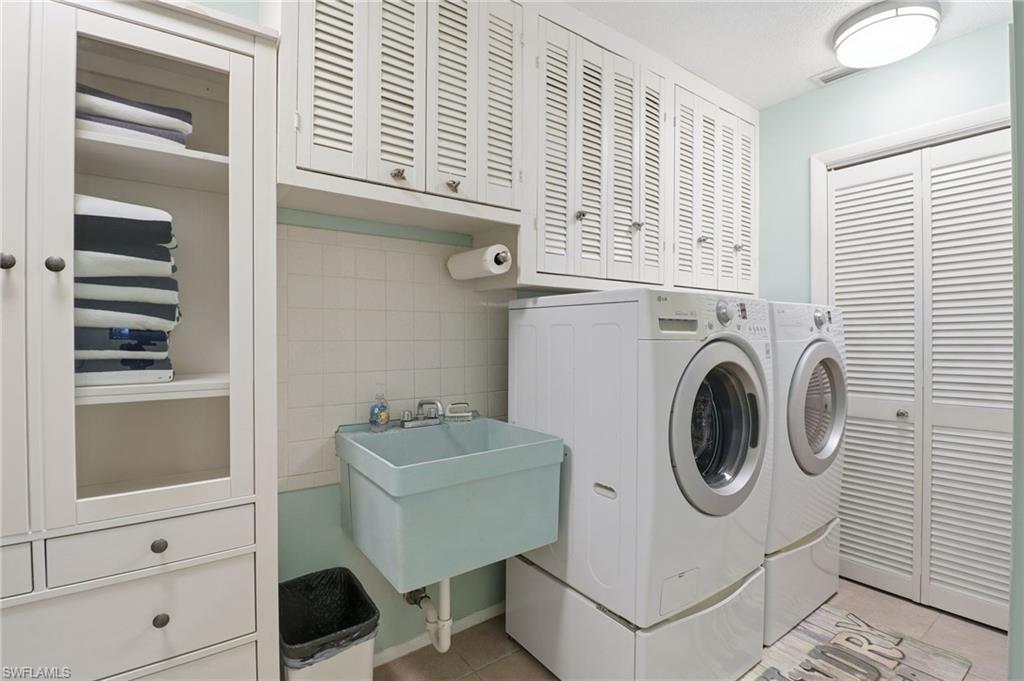 2211 Bayview Road Punta Gorda, FL 33950 - Photo 36 of 37 Laundry room with cabinet space, washer and dryer, light tile patterned floors, and tile walls
