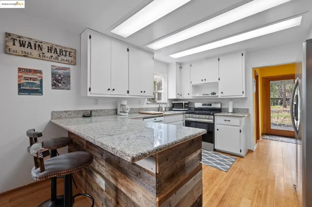 a kitchen with stainless steel appliances granite countertop a stove top oven a sink a counter space and cabinets