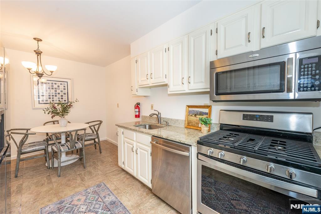 101 Gates Avenue, Unit 2A Montclair, NJ 07042 - Photo 11 of 21 a kitchen with stainless steel appliances a stove a sink cabinets and a dining table