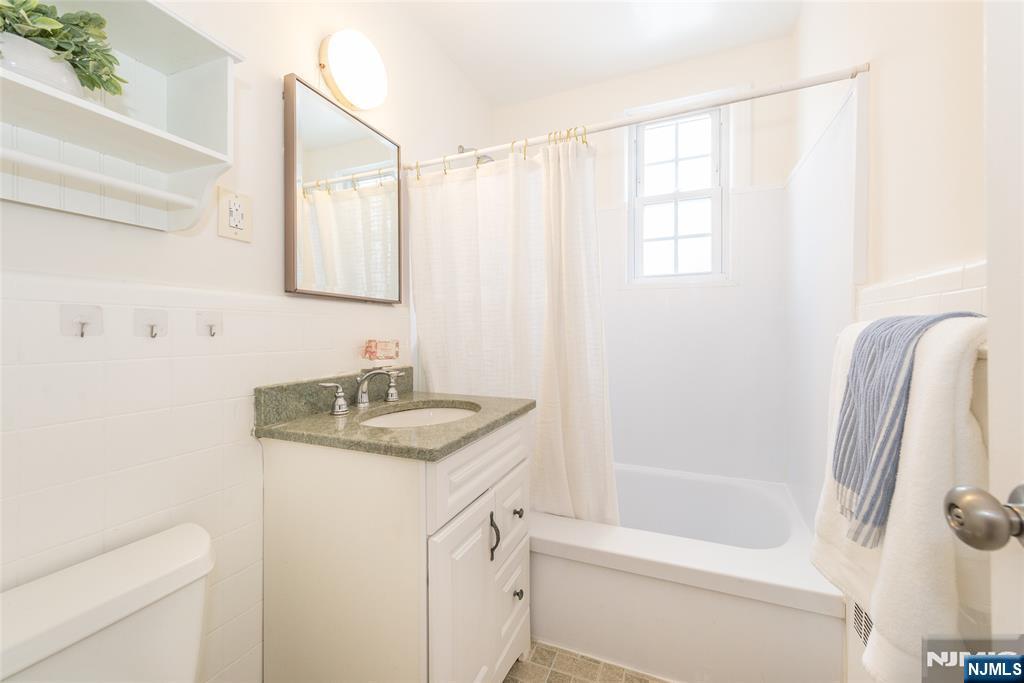 101 Gates Avenue, Unit 2A Montclair, NJ 07042 - Photo 15 of 21 a bathroom with a granite countertop sink a mirror and a shower