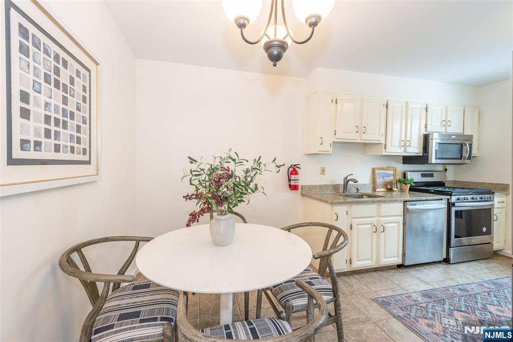 101 Gates Avenue, Unit 2A Montclair, NJ 07042 - Photo 10 of 21 a kitchen with stainless steel appliances granite countertop a sink a stove a dining table and chairs