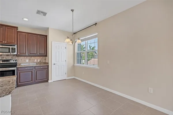 a kitchen with kitchen island granite countertop a stove refrigerator a sink and dishwasher with wooden floor