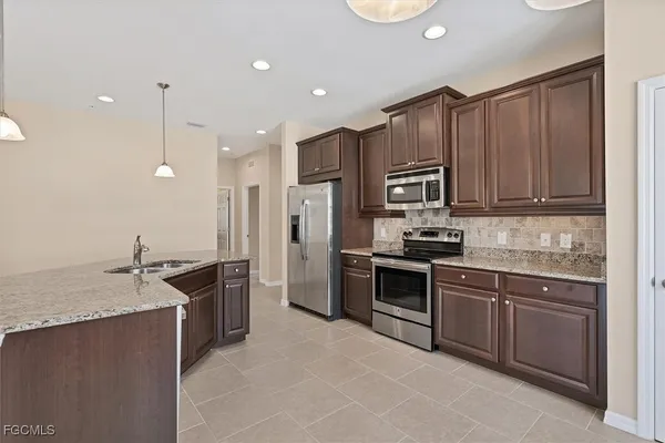 a kitchen with stainless steel appliances granite countertop a sink stove and refrigerator