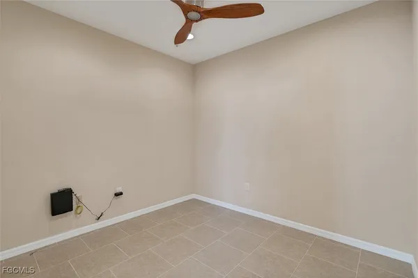 an empty room with a ceiling fan and carpet