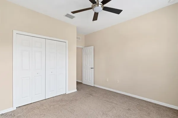 an empty room with a window and a fan