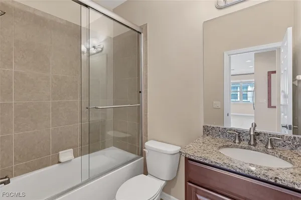 a bathroom with a granite countertop toilet sink and shower