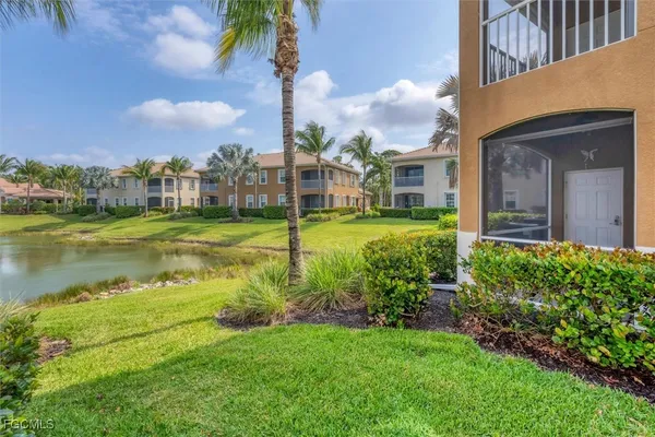 a view of a house with a big yard and a fountain