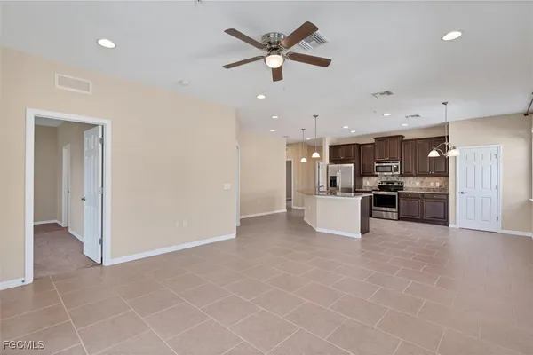 a view of kitchen with kitchen island stainless steel appliances a refrigerator sink and cabinets
