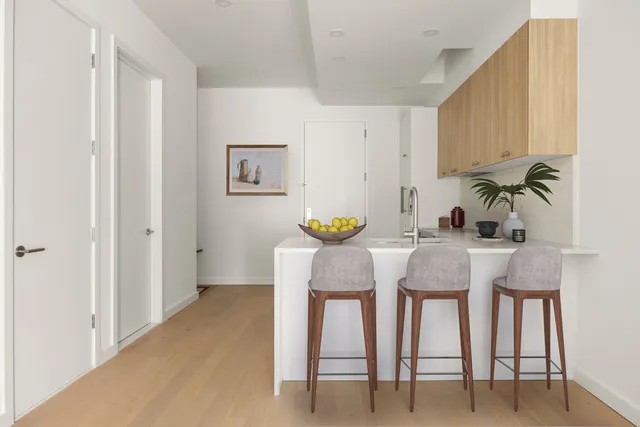 a kitchen with stainless steel appliances a stove and white cabinets