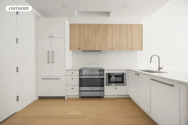 a kitchen with stainless steel appliances a stove and white cabinets