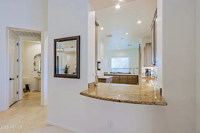 a kitchen with granite countertop white cabinets stainless steel appliances and a counter top