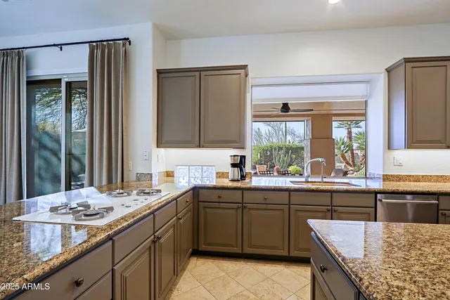 a living room with stainless steel appliances furniture and a kitchen view