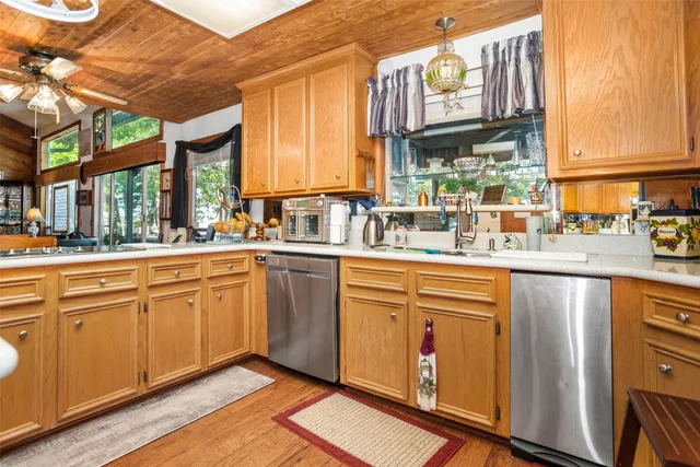 a kitchen with stainless steel appliances granite countertop a sink a stove and cabinets