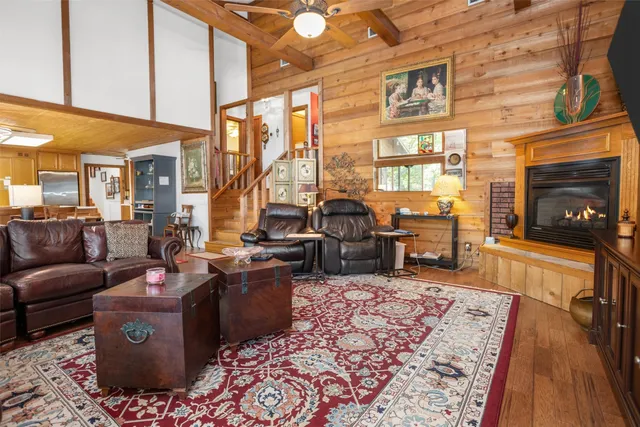 a living room with furniture a rug and a floor to ceiling window