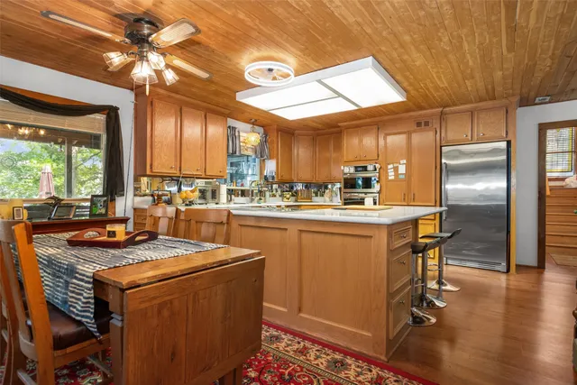 a kitchen that has a lot of cabinets in it and stainless steel appliances